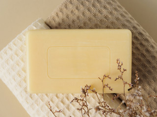 Handmade soap, towels and dried flowers on beige background