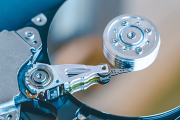 Hard disk drive platter.Disassembled hard drive from the computer with mirror effect. HDD) .Detail of writing/reading head on actuator arm and axis, spindle and platters.
