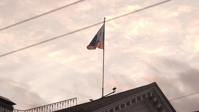 The Russian flag flies over the roof of the old building. Evening. Summer.