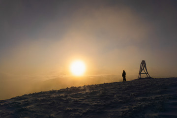 Panoramic view of man who meets beautiful sunrise in winter carpathians.  Borzhava ridge. Ukraine