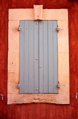 Fototapeta na wymiar A colourful wooden shuttered window on a building in Provence France
