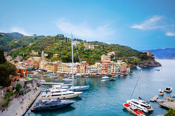 Fototapeta na wymiar Beautiful small village Portofino with colorfull houses, luxury boats and yachts in little bay harbor. Liguria, Italy. On warm brigth summer day
