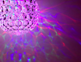 pink and purple disco ball with color shadows on the background.
