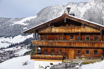 Alpbach mit typischen traditionellen Holzhaus im Winter mit Schnee
