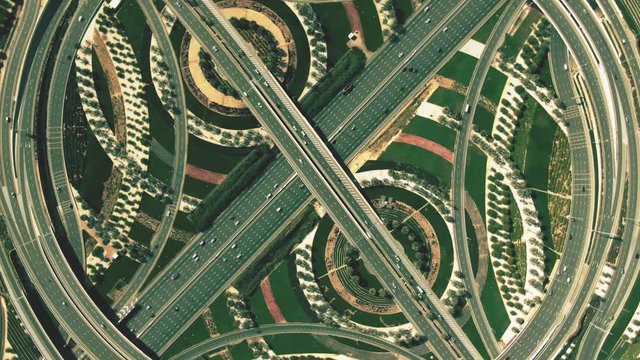 Aerial top down hyperlapse of a major highway interchange traffic resembling percent sign