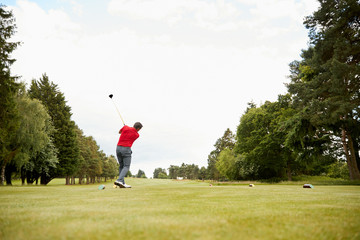 Mature Male Golfer Hitting Tee Shot Along Fairway With Driver