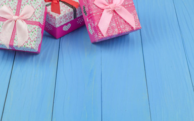 Three gift boxes on bule wooden background.