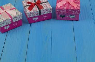 Three gift boxes on bule wooden background. Place the gift box in the upper right corner to allow space for the greeting text below.
