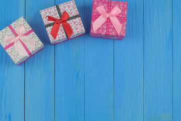 Three gift boxes on bule wooden background. Place the gift box in the upper right corner to allow space for the greeting text below.