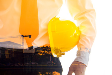 Double exposure of Engineering management construction ,engineer hold in hand yellow helmet for workers security on working site background.