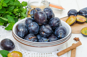 Fresh raw organic plum with jam ingredients on a white wooden background. Horizontal orientation.