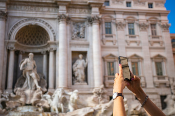 A girl is photographing the Trevi Fountain in Rome, Italy