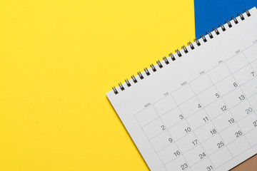 close up of calendar on the yellow and blue table, planning for business meeting or travel planning concept