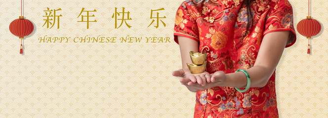 Chinese New Year, woman hands holding Chinese gold bar in hands with text and copy space.