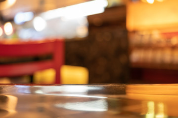 A gloss polish table top finishing in the coffeeshop with red chair blur background