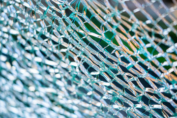 A detail close up of cracked blue green tempered glass