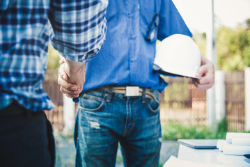 Engineers shaking hands at construction site house building for happy living.