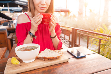 Asian woman eating hot vegetarian soup in cafe. Healthy diet and dinner concept