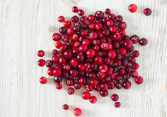 fresh cranberries on white wooden surface