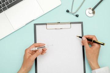 Female doctor working at workplace with laptop