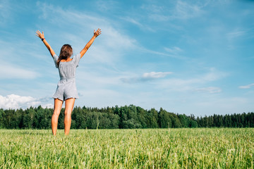 Beautiful girl in dress on green field