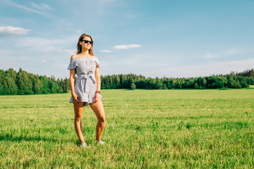 Beautiful girl in dress on green field