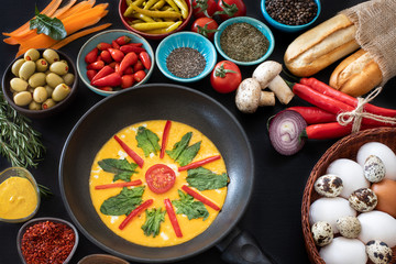 Fried eggs with avocados on the black table with many types of spices