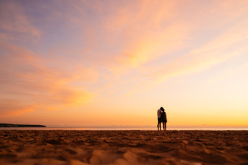 Couple kissing on the beach with a beautiful sunset