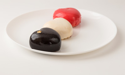 color mousse cakes in the shape of a heart decorated with mini hearts on a white  background. Valentine. Love. Valentine's Day postcard. Love concept for mother's day and valentine's day. 