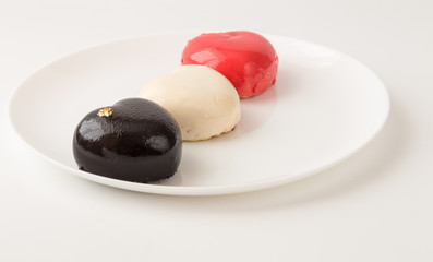 color mousse cakes in the shape of a heart decorated with mini hearts on a white  background. Valentine. Love. Valentine's Day postcard. Love concept for mother's day and valentine's day. 