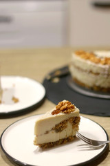 Slice of vegan cake with walnuts, cashew nuts and raisins. Selective focus.