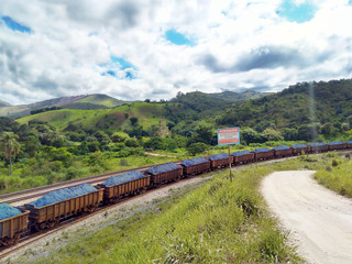 Ore-laden train passing with beautiful countryside in the background on a typical summer day in...