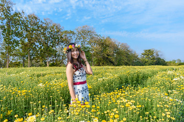 Smile girl with flower crown on hair smell blossom white flower.