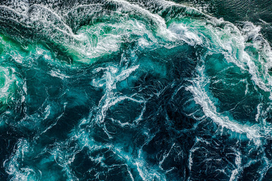 Abstract background. Waves of water of the river and the sea meet each other during high tide and low tide. Whirlpools of the maelstrom of Saltstraumen, Nordland, Norway © Andrei Armiagov