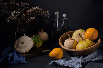 Still life in a dark key with pumpkins in rustic style
