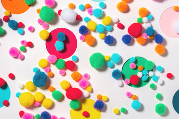 Holiday background with colorful soft fluffy balls for holiday decor and round holes in the background