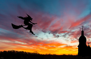 Silhouette of weather vane with witch flying on broomstick