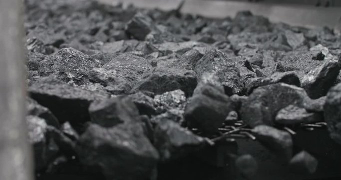 Conveyor belt with coal shooting in slow motion. Close-up there is coal on belt conveyor. Conveyor belt coal. Machine for loading mining in coal obage factory