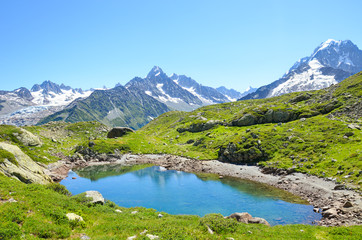 Naklejka na ściany i meble Glacier Lac de Cheserys, Lake Cheserys near Chamonix-Mont-Blanc in French Alps. Alpine lake with snow-capped mountains in the background. Tour du Mont Blanc trail. The Alps in the summer season
