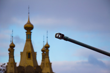 gun barrel against the background of the church of the LPR.