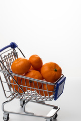 Trolley with tangerines on a white background