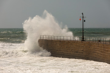 Big waves breaking over the Pier at Porthlevan during a winter storm