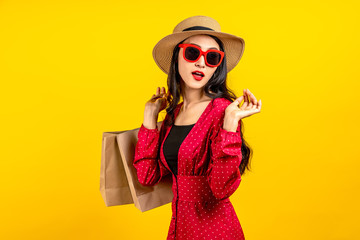 Asian trendy shopaholic woman excited about new purchases or sales holding shopping bags and...