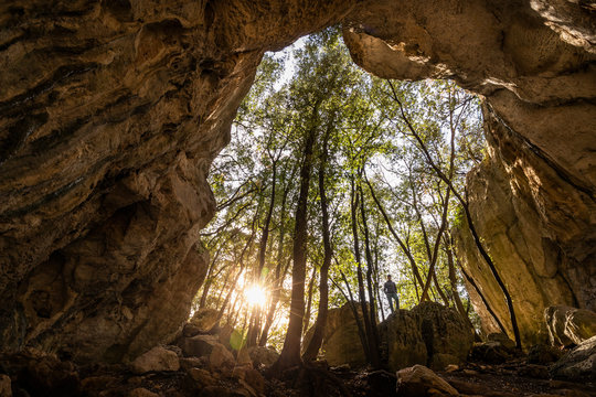 Woman at the exit of a cave in backlight, Finale Ligure, Liguria, Italy
