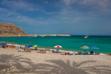 beach with umbrellas and chaise lounges-javea