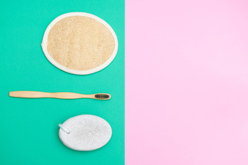 Eco-friendly body care accessories on pink and green paper background