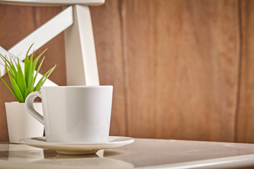 White cup of hot coffee or tea on wooden background. Close up. background