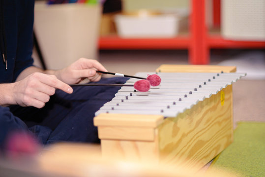 Playing a xylophone musical instrument.