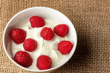 Cottage cheese with raspberries in a white bowl.