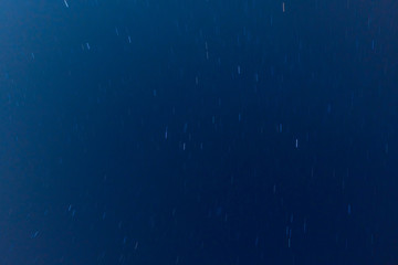 View to the moving stars at night, dark blue sky background. Long exposure shot. 
